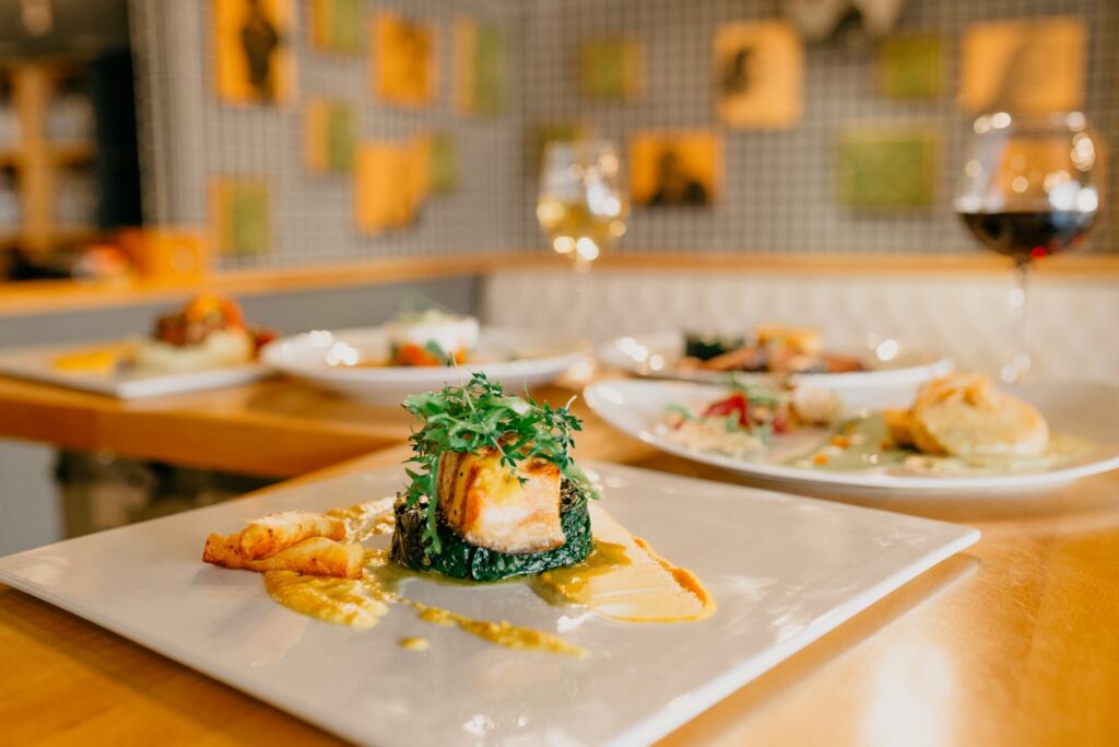 Plated dishes and wine glasses on a restaurant counter